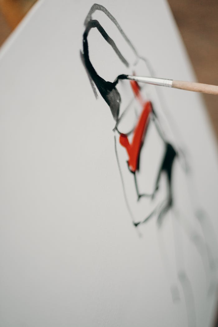 Close-up of an abstract painting being created with bold brushstrokes and vibrant colors.